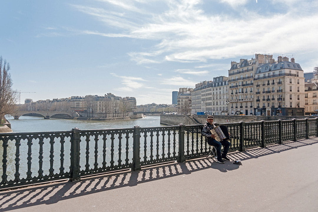 Man sitting on bench with accordion in Paris